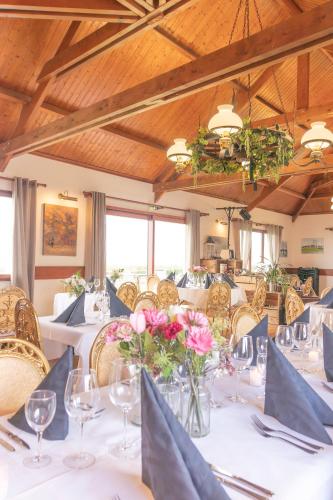 une salle à manger avec des tables blanches, des chaises et des fleurs dans l'établissement Nuit insolite à la campagne, à Fiennes