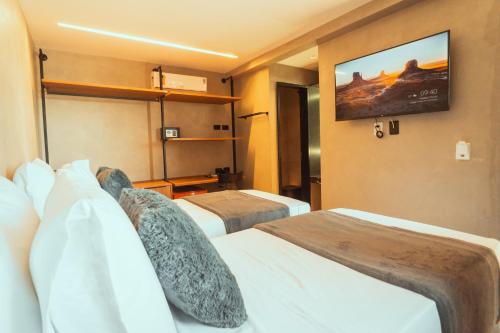 ein Hotelzimmer mit 2 Betten und einem Flachbild-TV in der Unterkunft Marilyn Pousada Morro in Morro de São Paulo