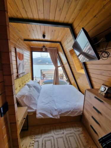 a small bedroom with a bed and a window at Chalet by the lake in Piatra Neamţ