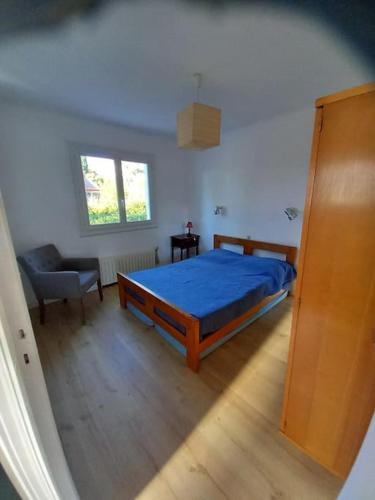 - une chambre avec un lit bleu et une chaise dans l'établissement Havre de paix, mer et jardin luxuriant, à Fréjus