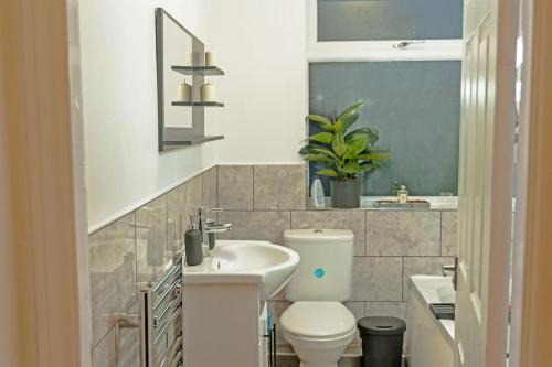 a bathroom with a toilet and a sink at A Cosy, Elegant 3 Bed Suite in Killingbeck