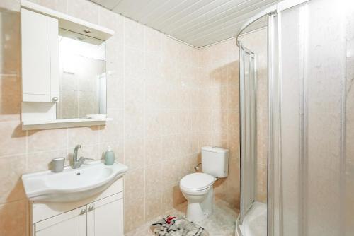 een badkamer met een toilet, een wastafel en een douche bij Cozy Flat with Balcony 10 min to Hadrian Gates in Antalya