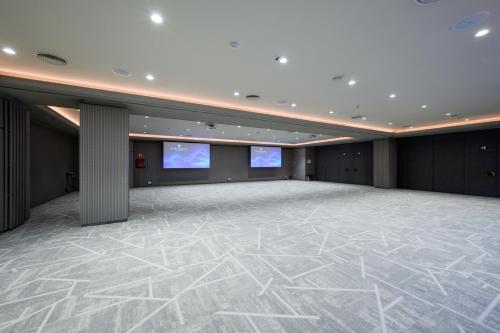a large room with two screens on the ceiling at InterContinental Barcelona by IHG in Barcelona