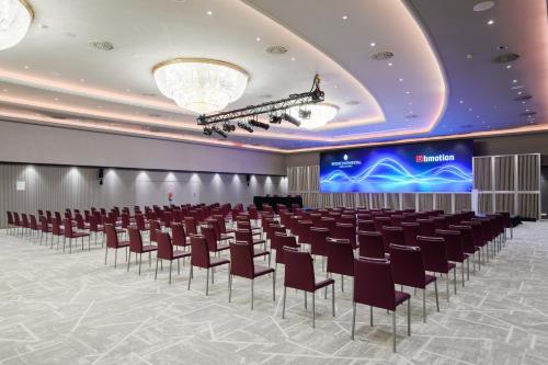 a conference room with rows of chairs and a stage at InterContinental Barcelona by IHG in Barcelona