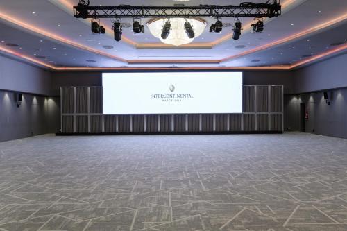 an empty room with a stage and a large screen at InterContinental Barcelona by IHG in Barcelona