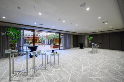 a lobby with tables and chairs in a building at InterContinental Barcelona by IHG in Barcelona