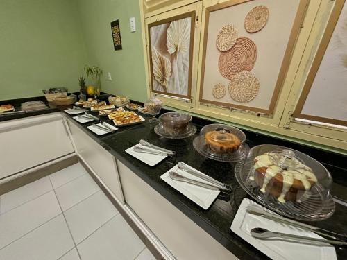 a kitchen counter with a bunch of food on it at Pousada Manaíra in João Pessoa