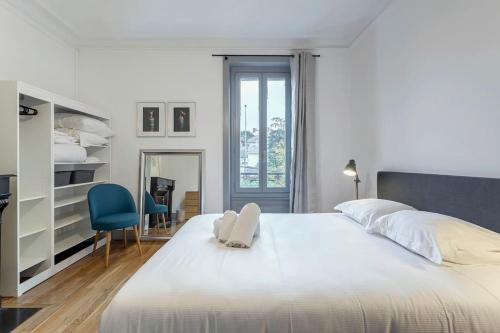 a bedroom with a white bed and a blue chair at 10' de Lyon- Appartement Tassin Centre - 2 Parking in Tassin-la-Demi-Lune