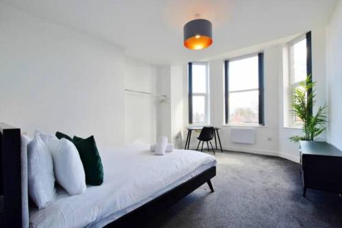 ein Schlafzimmer mit einem weißen Bett und grünen Kissen in der Unterkunft FREE PARKING - Beautiful 2-BR Flat in Manchester in Manchester