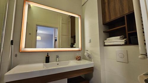 een badkamer met een wastafel, een spiegel en handdoeken bij HOLIDAY HOME Bel Mare 406b in Międzyzdroje