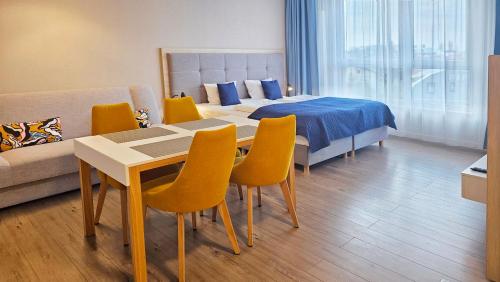 een slaapkamer met een bed en een tafel en stoelen bij HOLIDAY HOME Bel Mare 406b in Międzyzdroje