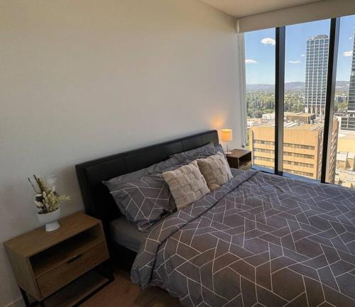 a bedroom with a bed with a view of a city at The Forest in the heart of CBD in Adelaide