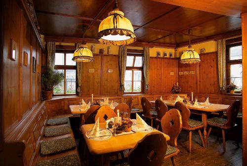 una sala da pranzo con tavoli, sedie e lampadari a braccio di Altdeutsches Gasthaus Roter Hirsch a Jena