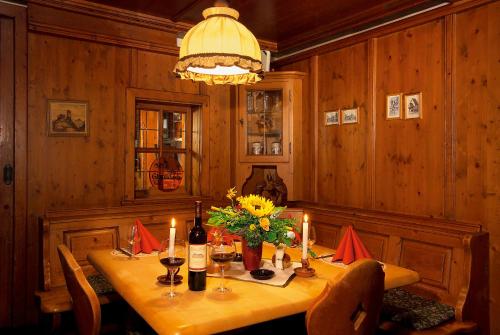 ein Esszimmer mit einem Tisch mit Blumen und Kerzen in der Unterkunft Altdeutsches Gasthaus Roter Hirsch in Jena