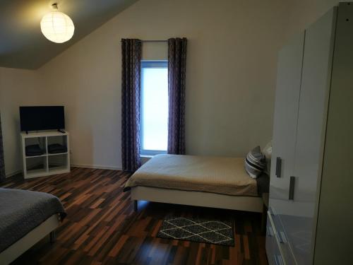 ein kleines Schlafzimmer mit einem Bett und einem Fenster in der Unterkunft Ferienwohnung am Waldpfad in Kaiserslautern