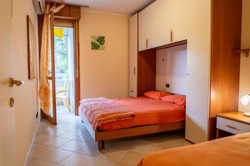 a bedroom with a bed and a door to a balcony at CONDOMINIO LA QUERCIA in Bibione