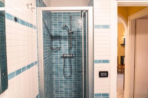 a shower in a bathroom with blue tiles at CONDOMINIO LA QUERCIA in Bibione