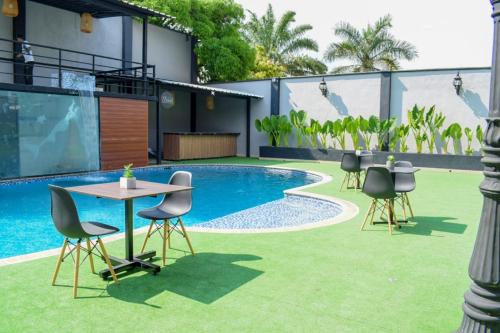 a patio with a table and chairs next to a pool at Hotel Boutique Ciudad Jardin in Cali