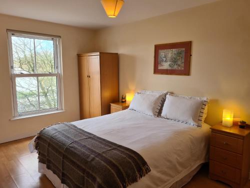 - une chambre avec un lit, deux lampes et une fenêtre dans l'établissement Quay village 16, à Westport