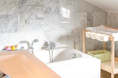 een badkamer met een bad en een wastafel bij La Petite Baraque in Vielsalm