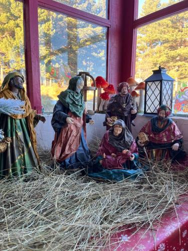 a group of people sitting on hay in a room at Gîte Ranch Le Serpolet in Les Angles