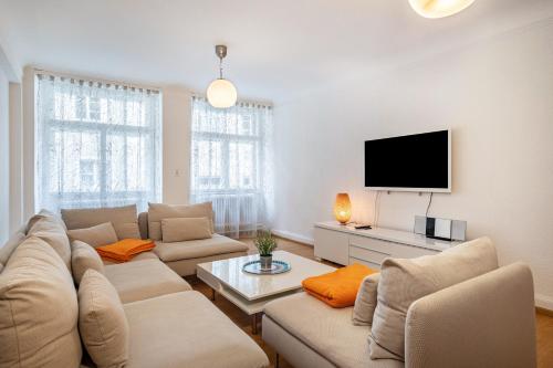 sala de estar con 2 sofás y TV de pantalla plana en Ferienwohnungen Spiegel Cramergasse en Lindau