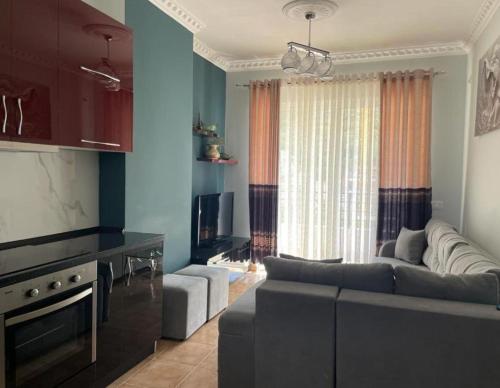 sala de estar con sofá y TV en Topi Apartments, en Vlorë