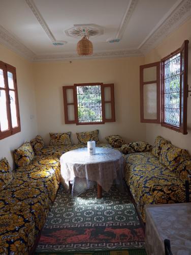 a living room with a couch with a table at Dar Lala Zhour in Aïn Bouchrik
