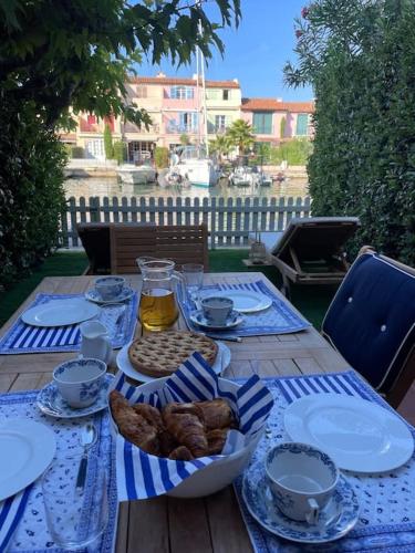 une table avec un chiffon de table bleu et blanc et de la nourriture dans l'établissement Fisherman's house in the heart of Port Grimaud, à Grimaud