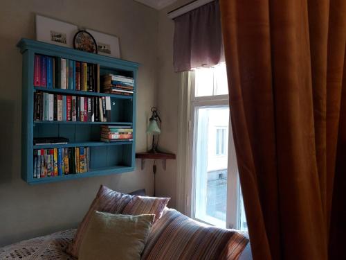 um quarto com uma estante de livros, um sofá e uma janela em Nummenpakan Pysäkki em Turku