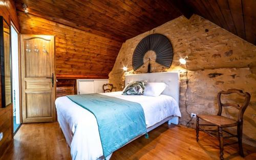 une chambre avec un lit et un mur en bois dans l'établissement Le Secret d'Enoiseuses - Centre historique, à Sarlat-la-Canéda