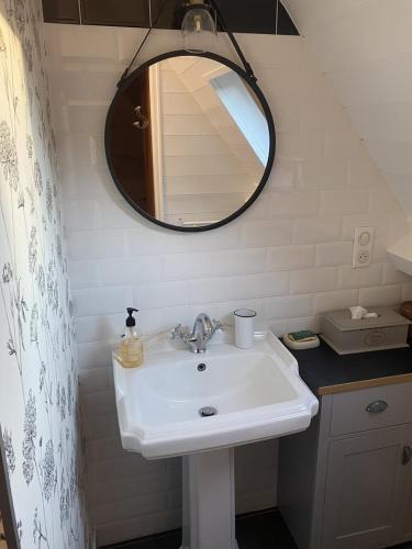 une salle de bain avec un lavabo blanc et un miroir dans l'établissement Le Secret d'Enoiseuses - Centre historique, à Sarlat-la-Canéda