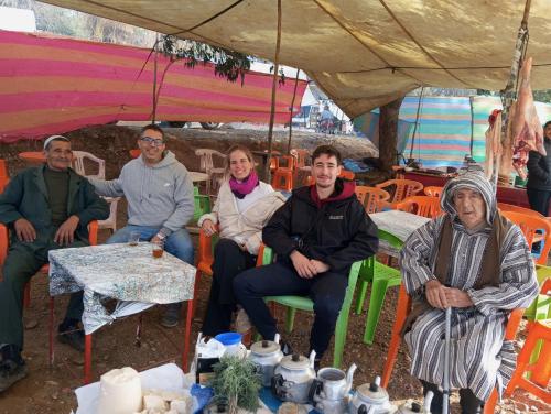 a group of people sitting in chairs under a tent at Dar Lala Zhour in Aïn Bouchrik