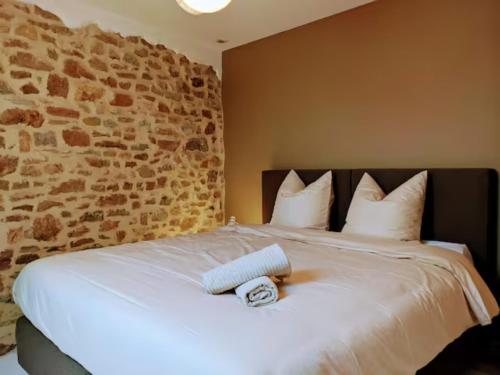 1 dormitorio con 1 cama con pared de piedra en La Reid, entre 2 vallées en Fraineux