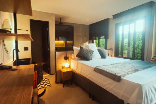 a bedroom with a large bed and a large window at Marilyn Pousada Morro in Morro de São Paulo