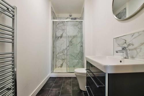 a bathroom with a shower and a sink and a toilet at FREE PARKING - Charming 2-BR Flat near Salford Royal in Manchester