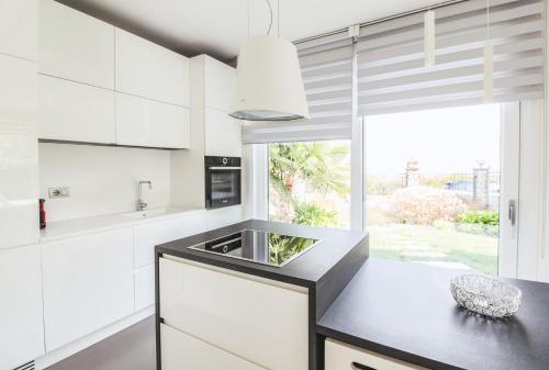 a kitchen with white cabinets and a sink and a window at La Sosta in San Siro