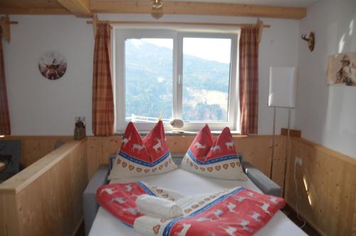 a room with a couch with pillows and a window at Much`s Bergstüberl in Wattenberg