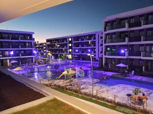 una piscina frente a un edificio por la noche en Muro alto porto de galinhas Makia experience en Porto De Galinhas