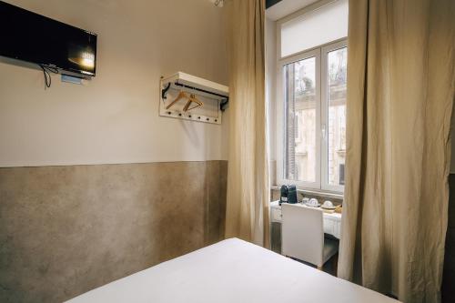 um quarto com uma cama e uma janela em Walker Rooms em Roma