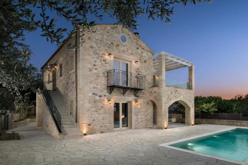 - une vue extérieure sur une maison en pierre avec une piscine dans l'établissement Villa Antonousa - Private Pool Oasis, à Kerá
