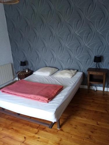 - un lit avec une couverture rouge dans l'établissement Maison Bretonne, à Cléden-Cap-Sizun