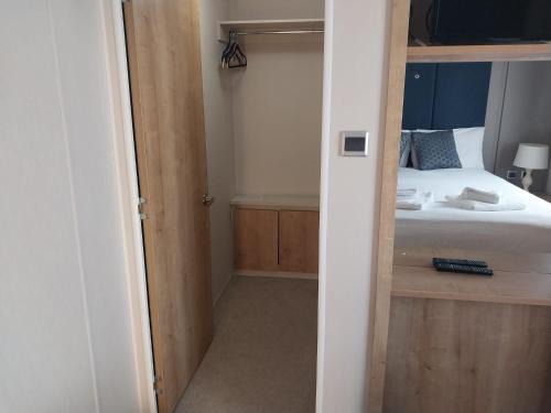 a bedroom with a bed and a door leading into a room at Camber Sands Holiday Park in Camber
