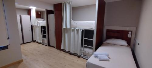 Habitación pequeña con 1 cama y 2 literas en Nómade Hostel mdz en Mendoza