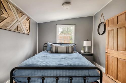 una camera da letto con un letto con lenzuola blu e una finestra di Creekside Cabin w Hot Tub, Fire Pit, Grill, WiFi! a Basye