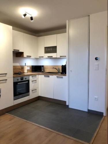 une cuisine vide avec des placards blancs et un évier dans l'établissement A dream apartment in Étaples, à Étaples