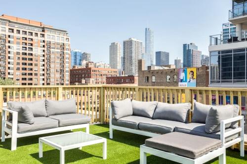 a balcony with two couches and a table and a city at Luxury Downtown Penthouse with Private Rooftop in Chicago