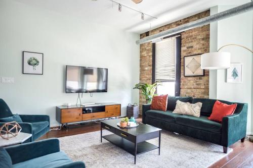 a living room with two blue couches and a tv at Luxury Downtown Penthouse with Private Rooftop in Chicago