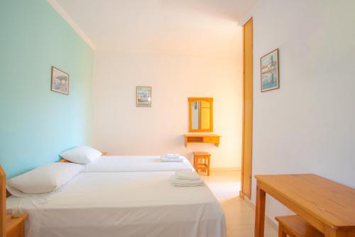 1 dormitorio con 2 camas y mesa de madera en Nydri Mediterraneo Apartament, en Nydri