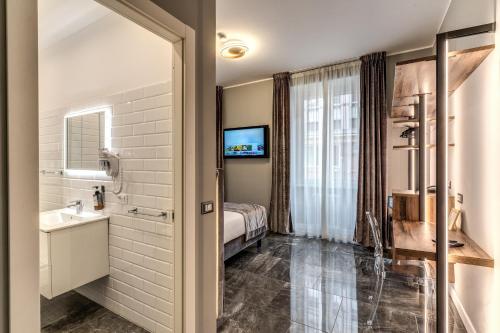 ein Bad mit einem Bett, einem Waschbecken und einem Spiegel in der Unterkunft Apollo Boutique Hotel in Rom